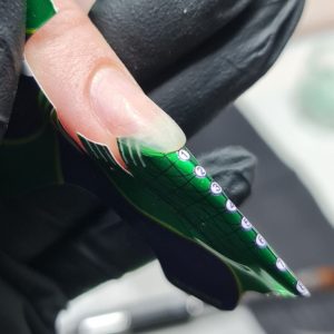 Elegante gelnagel met groene en witte details, perfect voor professionele nagelverzorging.